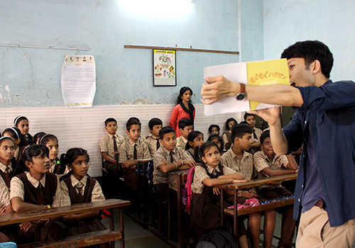 インド・ムンバイで子どもを前に絵本の読み聞かせを行う大学院生。